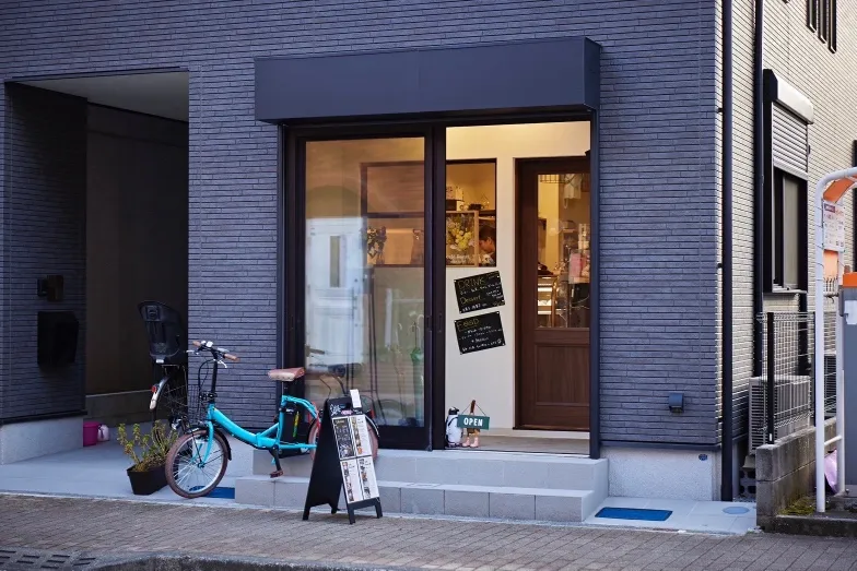 濃い色の外壁とガラスの入口が目印のcafe Roost外観