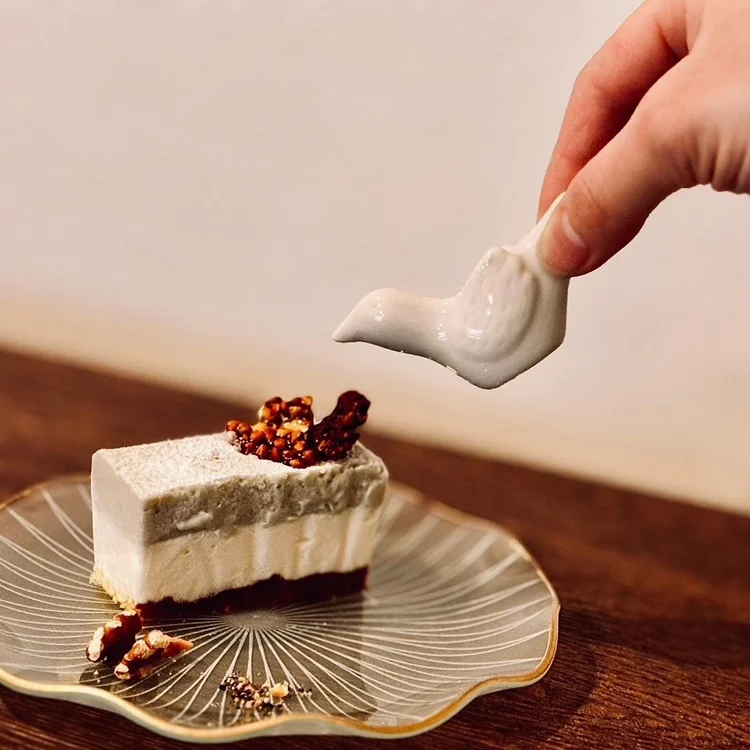 鳥形の器からソースを添える手作りケーキ