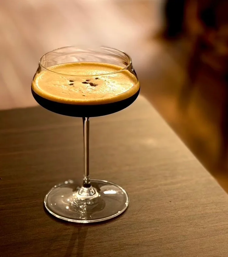 木のテーブルに置かれたコーヒー色のカクテル